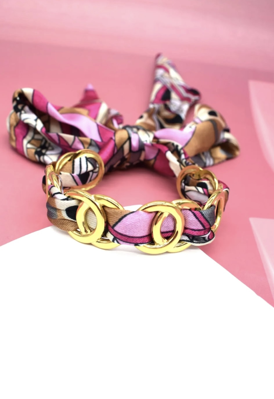 Bracelet chaîne dorée tressé avec un foulard rose